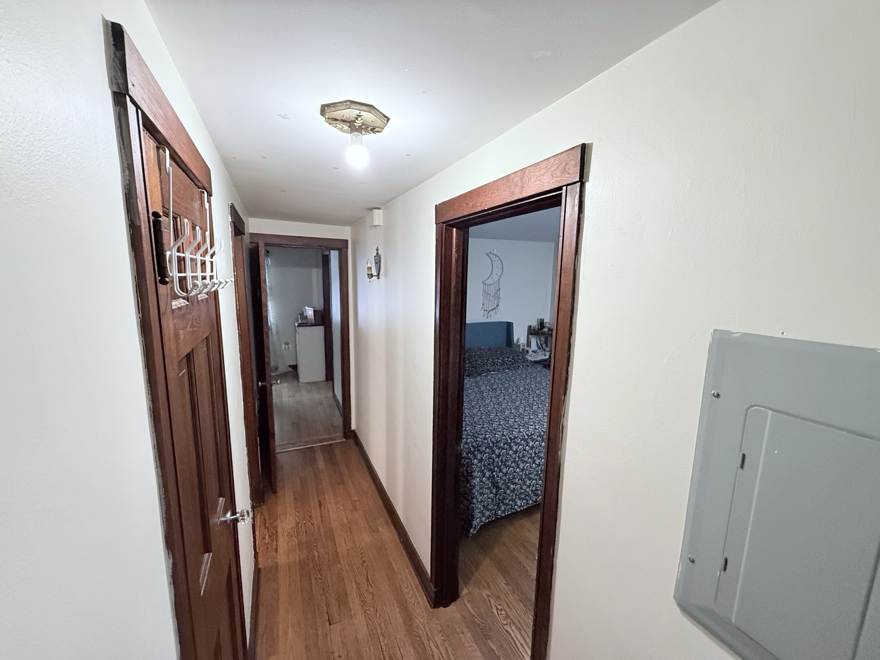 Buell St Airbnb hallway with wood floors and connecting room layout.