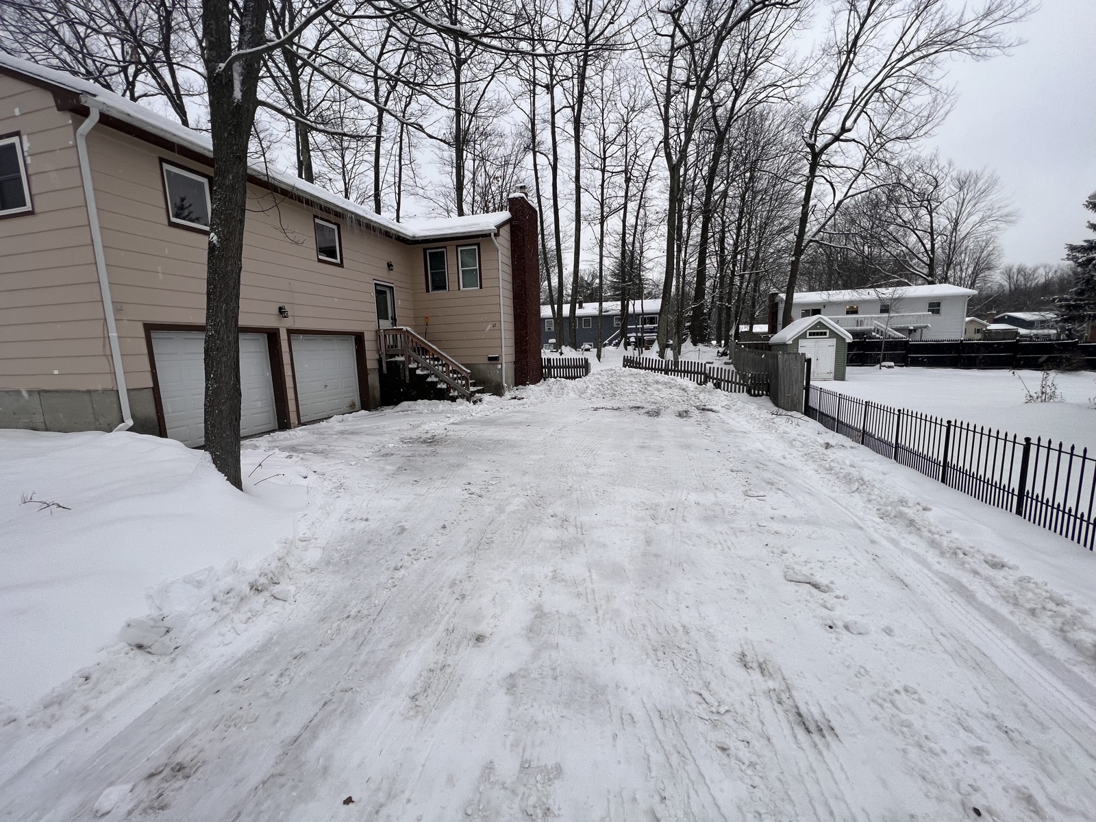 Rosewood Rental exterior driveway with parking and house approach in winter.